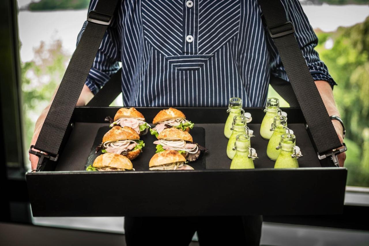 Le Méridien Hamburgo Exterior foto A waiter holding a tray of food